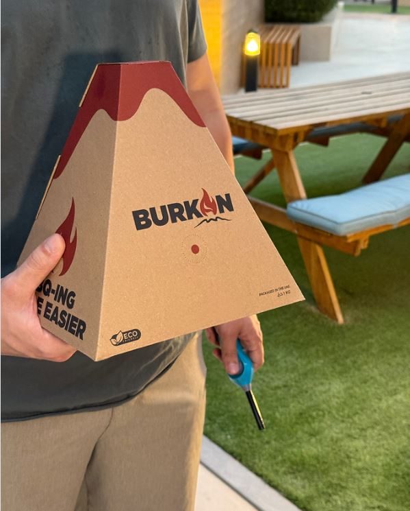 Burkan BBQ charcoal pyramid pack held in hand, ready for grilling